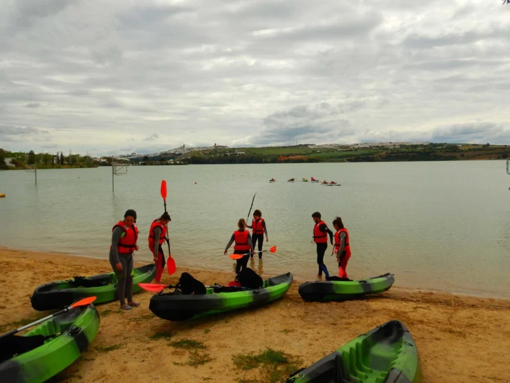 varias personas en el lago de arcos con kayaks