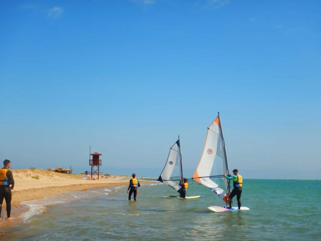 varias personas practicando windsurf en la costa gaditana
